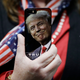 A woman holds up her cell phone before a rally with Republican presidential candidate Donald Trump, Thursday, Sept. 29, 2016, in Bedford, N.H.